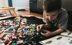 Stock Buying Process: child following instructions to assemble Legos