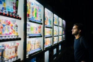 Stock buying process; puzzled man looking at vending machines