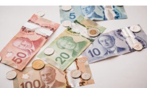 Canadian currency, bills and coins, on white background