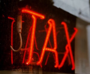 Word "tax" written in red neon lights.