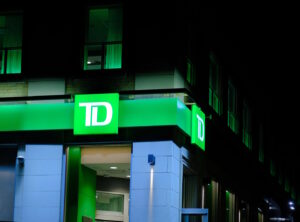 Picture of a branch of TD Bank on street corder with sign lit at night