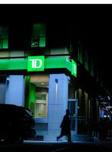 Branch of TD bank at night with lit sign