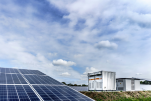 Solar panels with energy storage equipment in the background